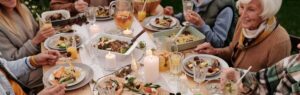mesa com comidas italianas e pessoas felizes ao redor